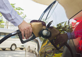 Un homme faisant le plein d'essence dans une station-service. 