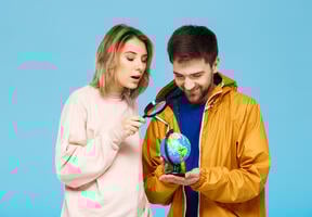 Friends looking at a world map through a magnifying glass