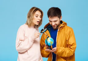 Friends looking at a world map through a magnifying glass