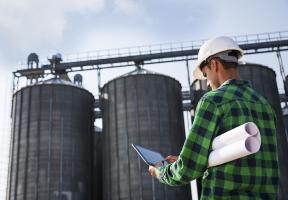 Un ouvrier faisant une intervention sur un site industrielle via son ordinateur
