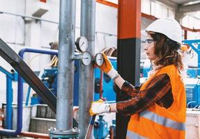 Industrial worker regulating the pressure of a compressed air pressure valve