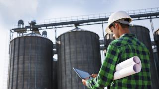 Un ouvrier faisant une intervention sur un site industrielle via son ordinateur