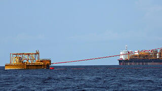 Oil tanker loading operation near a giant offshore barge 