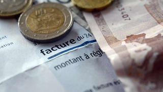 Photo of euro notes and coins on top of an electricity bill