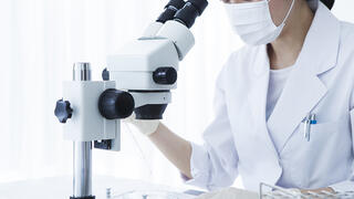 Scientifique qui regarde dans un microscope