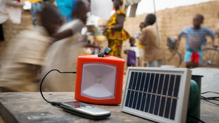 Decentralized solar power is changing people's lives in numerous households. Here, an ordinary solar panel recharges a lamp and a telephone.