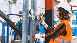 Ouvrière industrielle régulant la pression d'une vanne de pression d'air comprimé