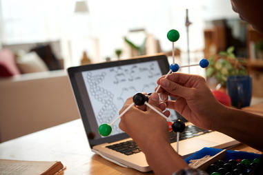 Mains d'enfant manipulant une maquette moléculaire